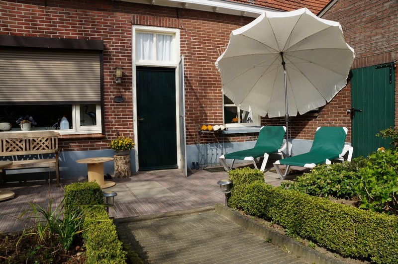 tuin met parasol en ligbedden